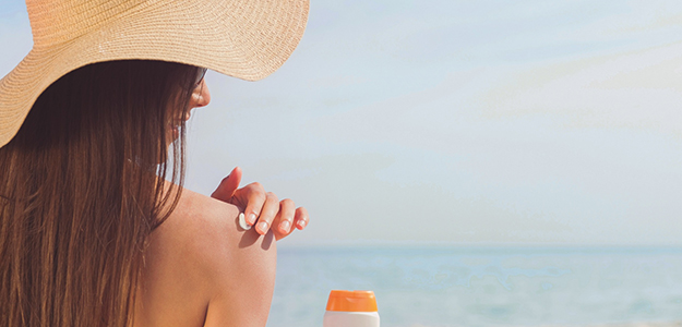 Woman applying sunscreen on beach