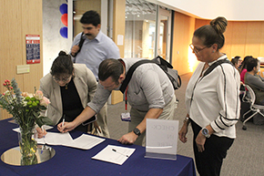 [Latecomers from the Division of Infectious Diseases, Carolyn Bothwell, Dr. Saman Nematollahi (behind her), Dr. Alex Perry, and Richelle Clemente, sign in for the Torchbearer Awards.]