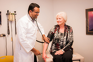 [Dr. Bijin Thajudeen (left) with a patient.]