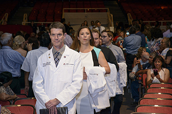 Dr. Kevin Moynahan leads a column of first-year med students