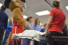 Wilbur listens in with high school students at the Labor & Delivery booth during health career fair
